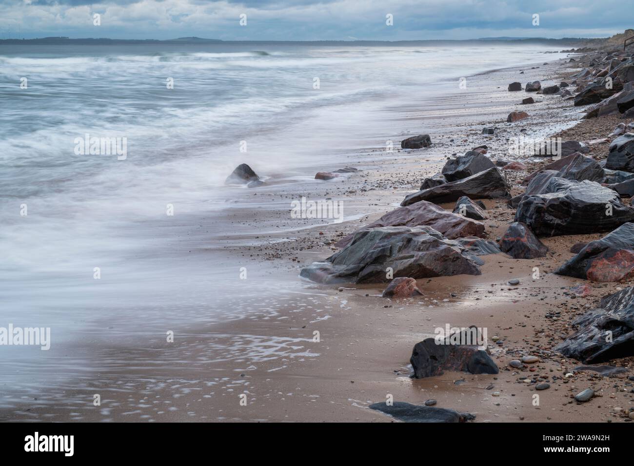 Rocks and sea on Findhorn beach in the winter. Findhorn, Morayshire Scotland. Long Exposure Stock Photo