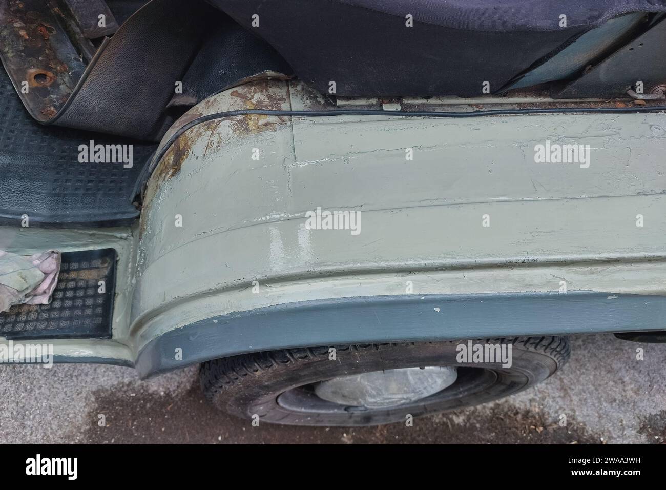 Welding a car or van inner fender. Repairing rust holes, removing rusty metal and painting it back. Step six - final paint on the surface in car color Stock Photo