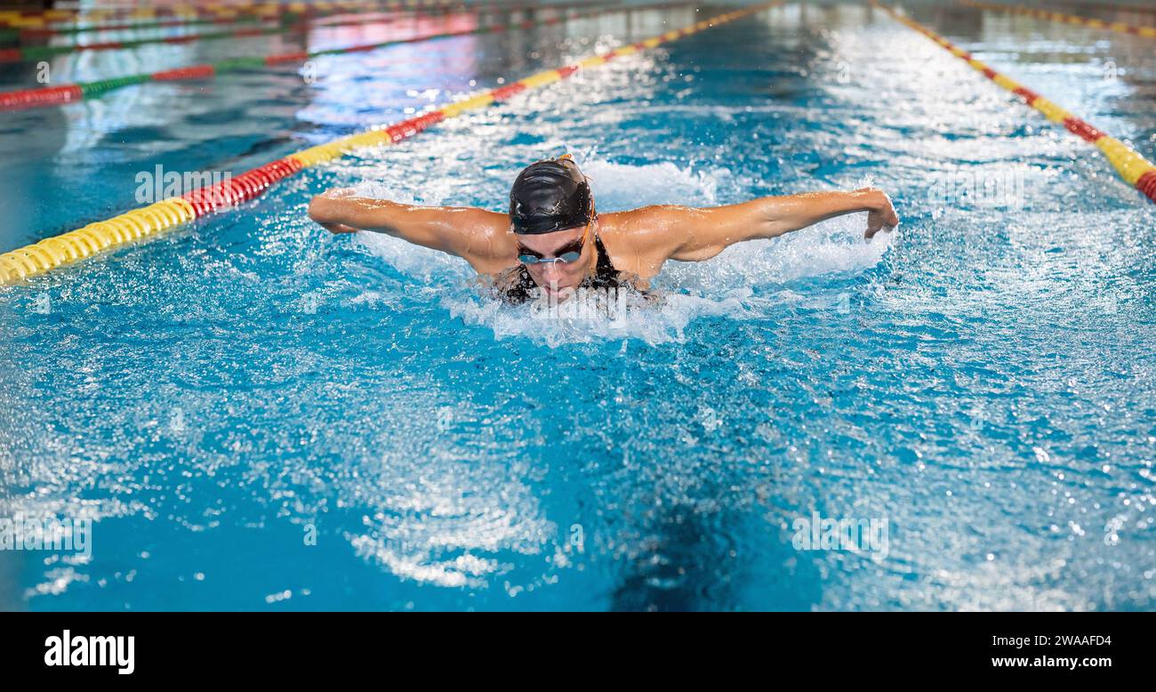 Front view of a powerful elite female swimmer competitor performing