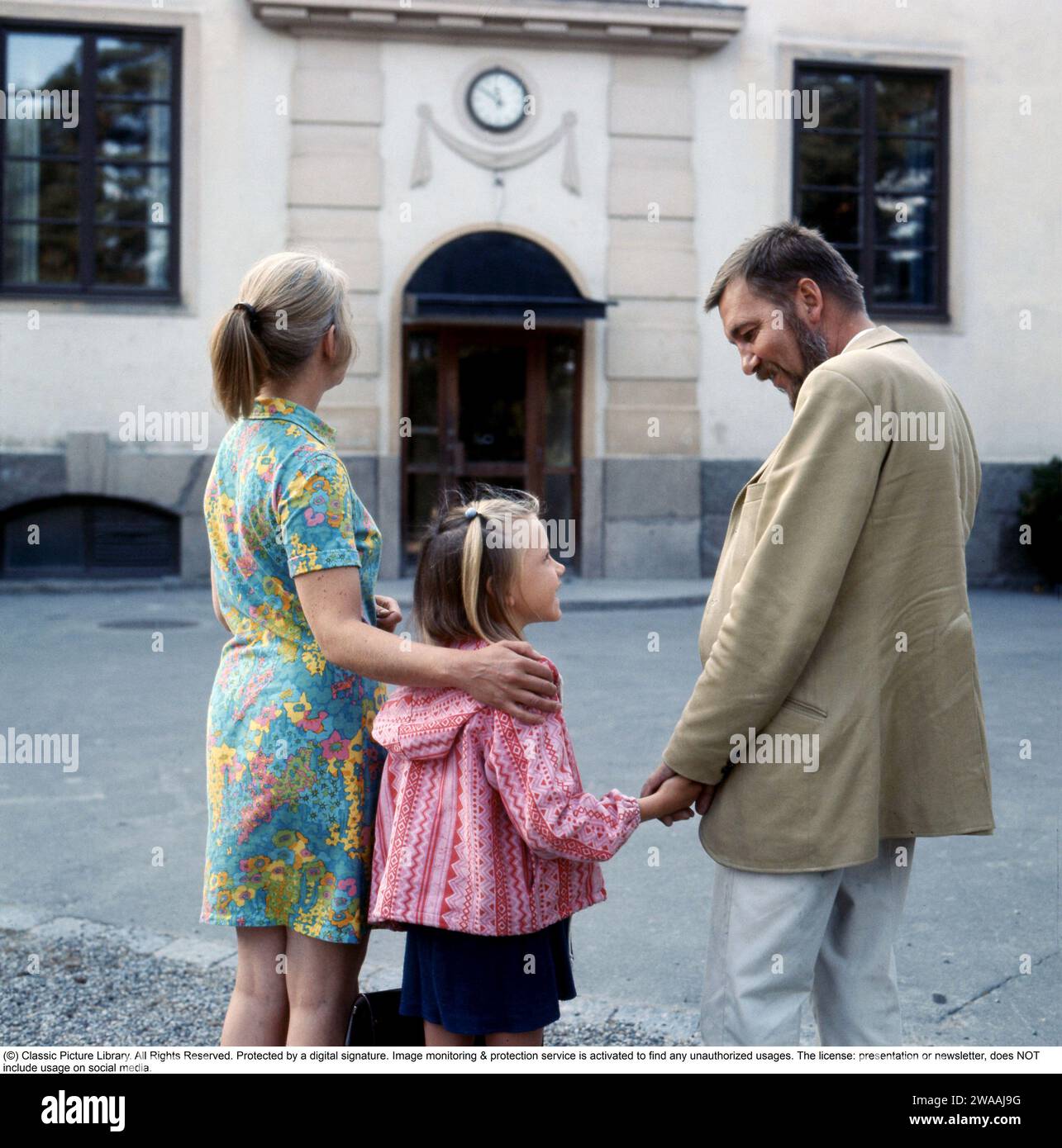 1960s parents. A mother and father are accompanying their daughter on her first day in school. 1969 Stock Photo