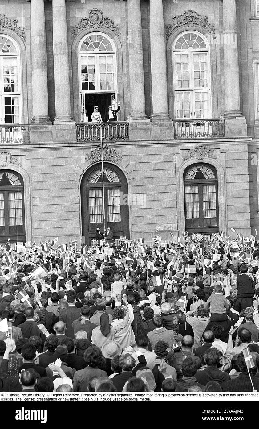 Margrethe II of Denmark. Pictured with Henri de Laborde de Monpezat at Fredensborg palace in Copenhagen after their wedding on June 10 1967. Greeted by a crowd of people waving flags. Stock Photo