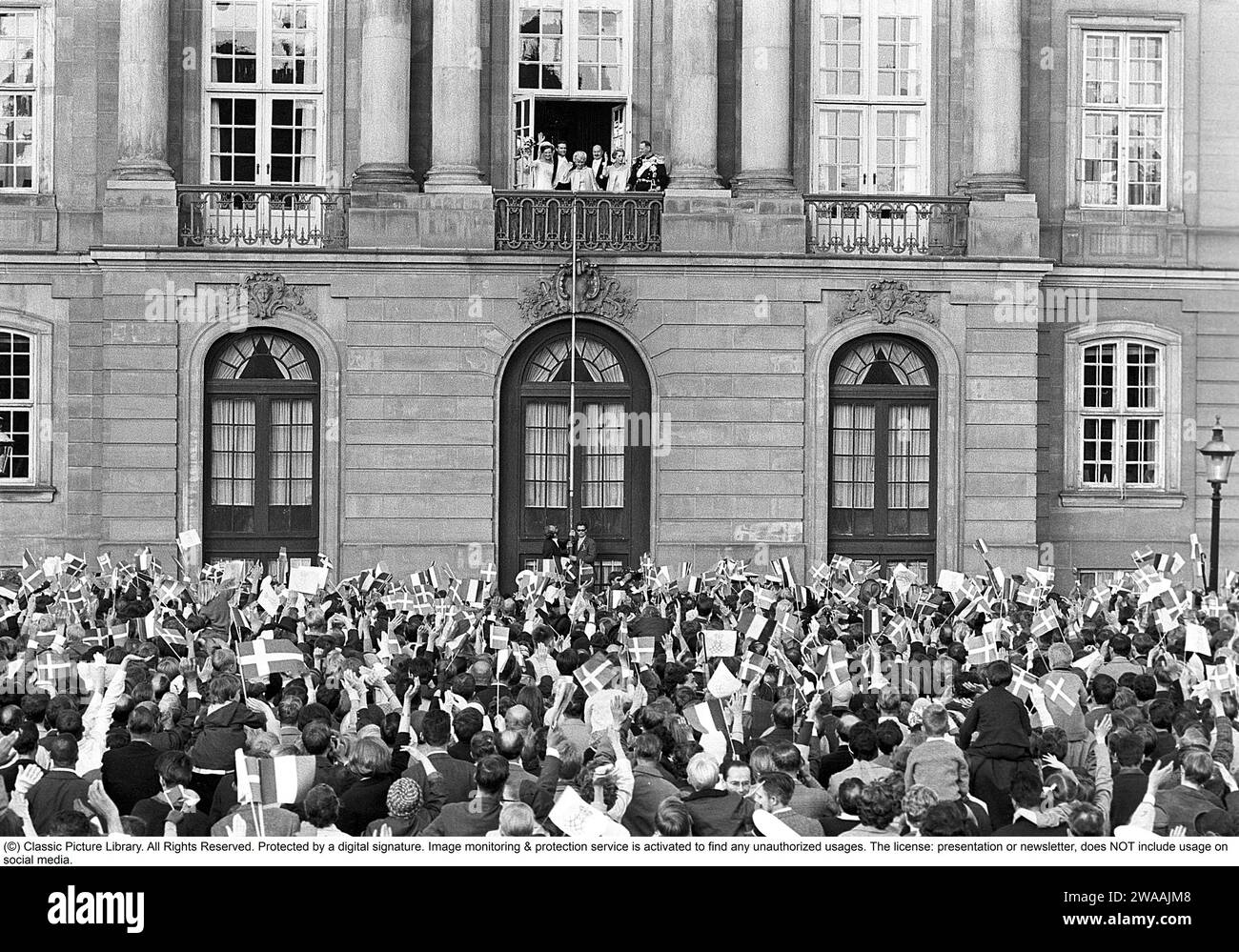 Margrethe II of Denmark. Pictured with Henri de Laborde de Monpezat at Fredensborg palace in Copenhagen after their wedding on June 10 1967. Greeted by a crowd of people waving flags. Stock Photo