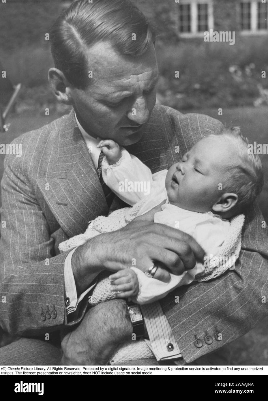 Queen Margrethe II of Denmark. Pictured in the arms of her father king Frederick IX august 1940. Stock Photo