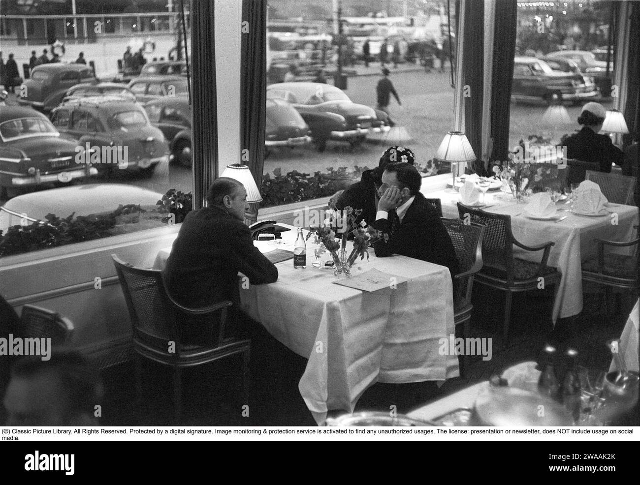 Frank Sinatra. American singer and actor. Born 12 December 1915, died 14 May 1998. Here on a visit to Sweden in 1953. He and his wife, the actress Ava Gardner, arrived by plane at Bromma airport on May 29, 1953 and are seen sitting at a window table at the Grand Hotel in Stockholm the same day. Frank Sinatra and Ava Gardner are seated on the right at the table.  Ref Anders Svahn Stock Photo