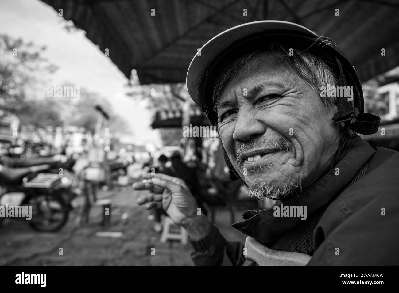 A man from Vietnam is smoking a cigarette Stock Photo