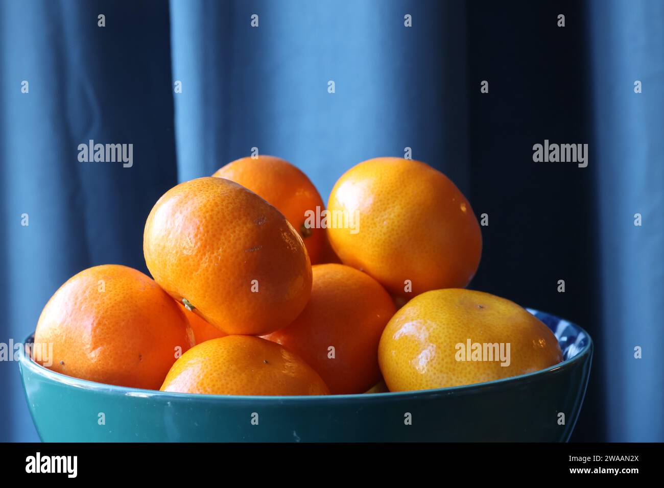 Easy peel oranges in a bowl with blue backdrop Stock Photo - Alamy