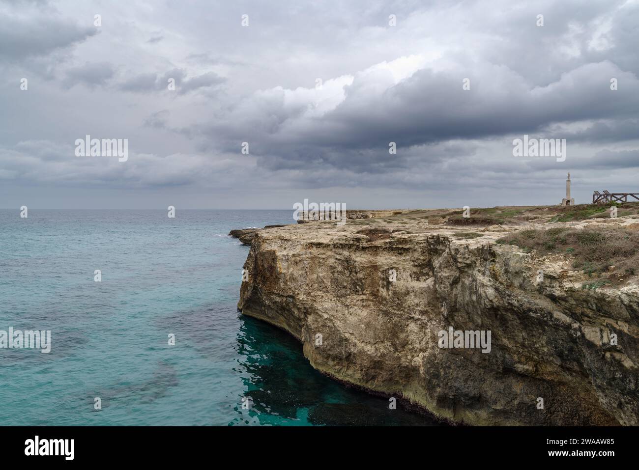 Poetry Cave (Grotta della Poesia) natural pool surrounded by rugged limestone cliffs with caves and a tunnel to the open sea. Apulia, Italy Stock Photo