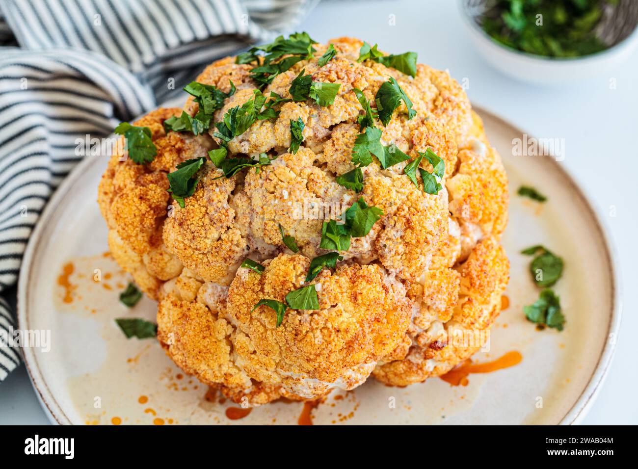 Roasted whole spicy cauliflower with tahini dressing Stock Photo - Alamy