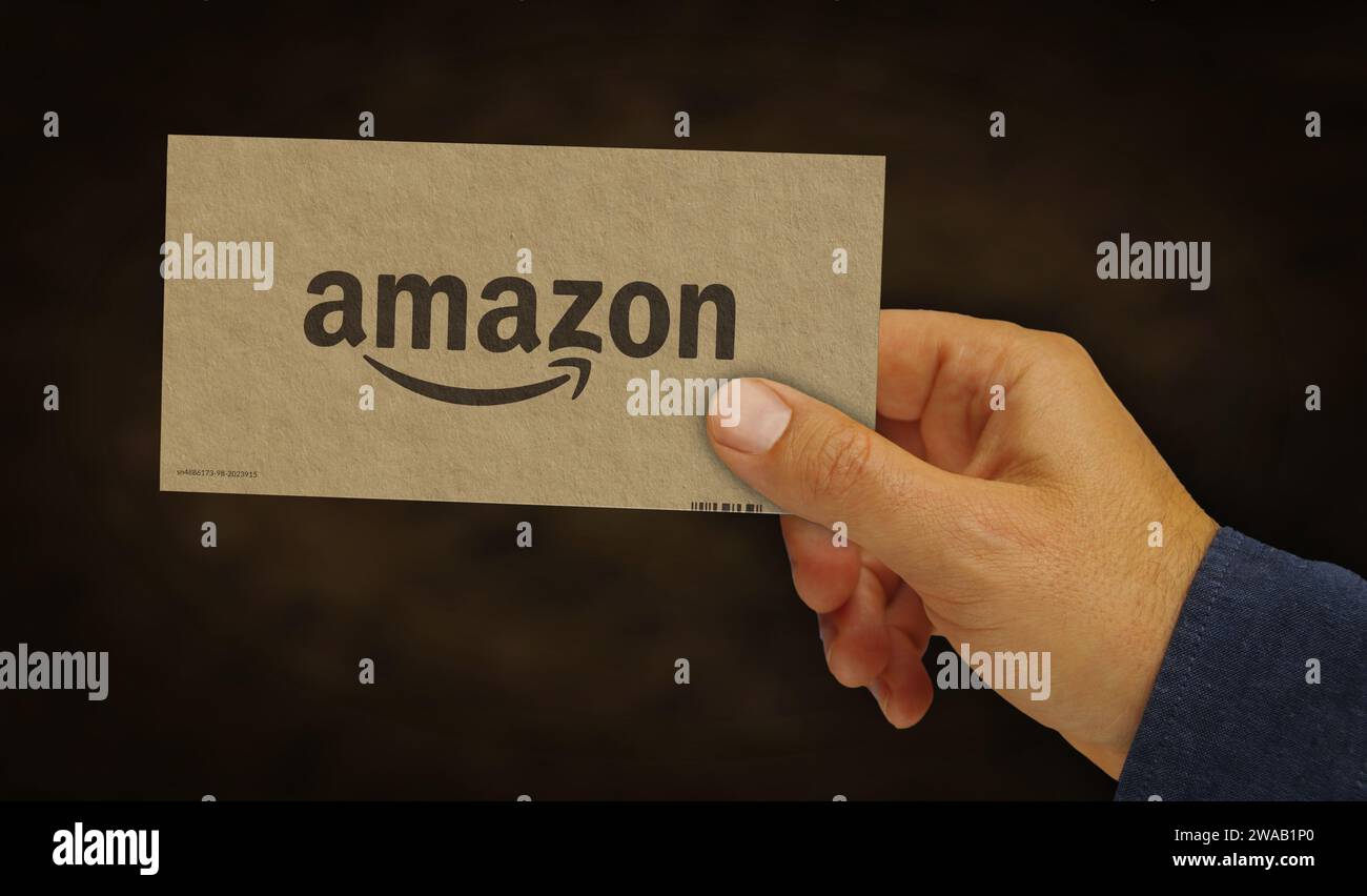 Poznan, Poland, January 2, 2024: Amazon e-commerce box in hand. E-business and online retail company. Cardboard pack factory. Abstract concept 3d rend Stock Photo