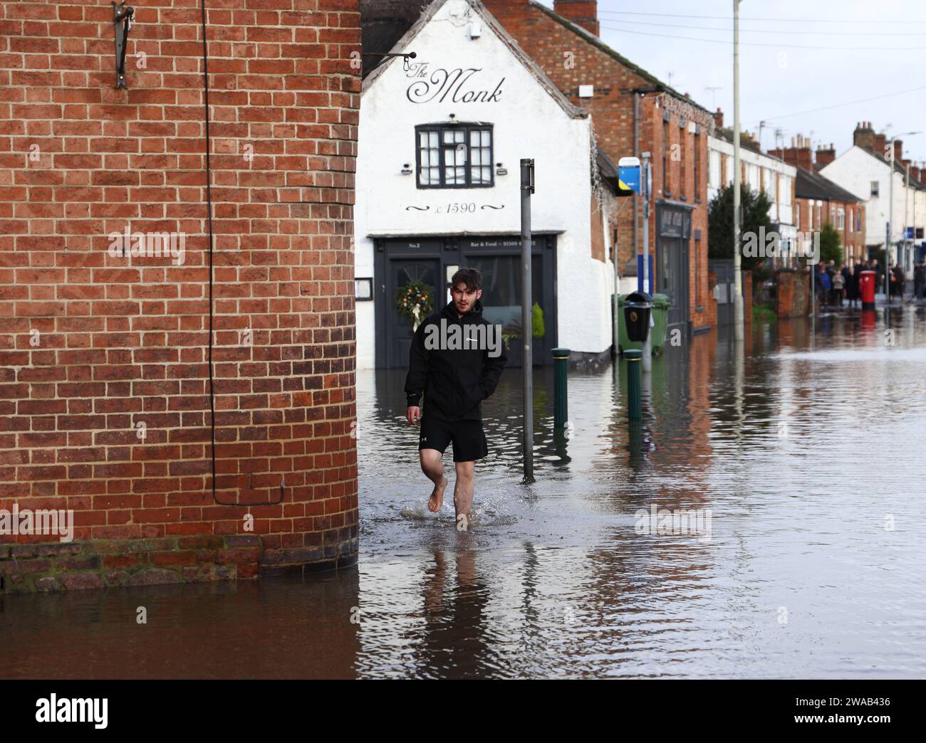 Quorn, Leicestershire, UK. 3rd January 2024. UK weather. A man wades past a restaurant sitting in flood water. Heavy rain and wind has battered large swathes of the UK after the small but potent Storm Henk hit.  Credit Darren Staples/Alamy Live News. Stock Photo