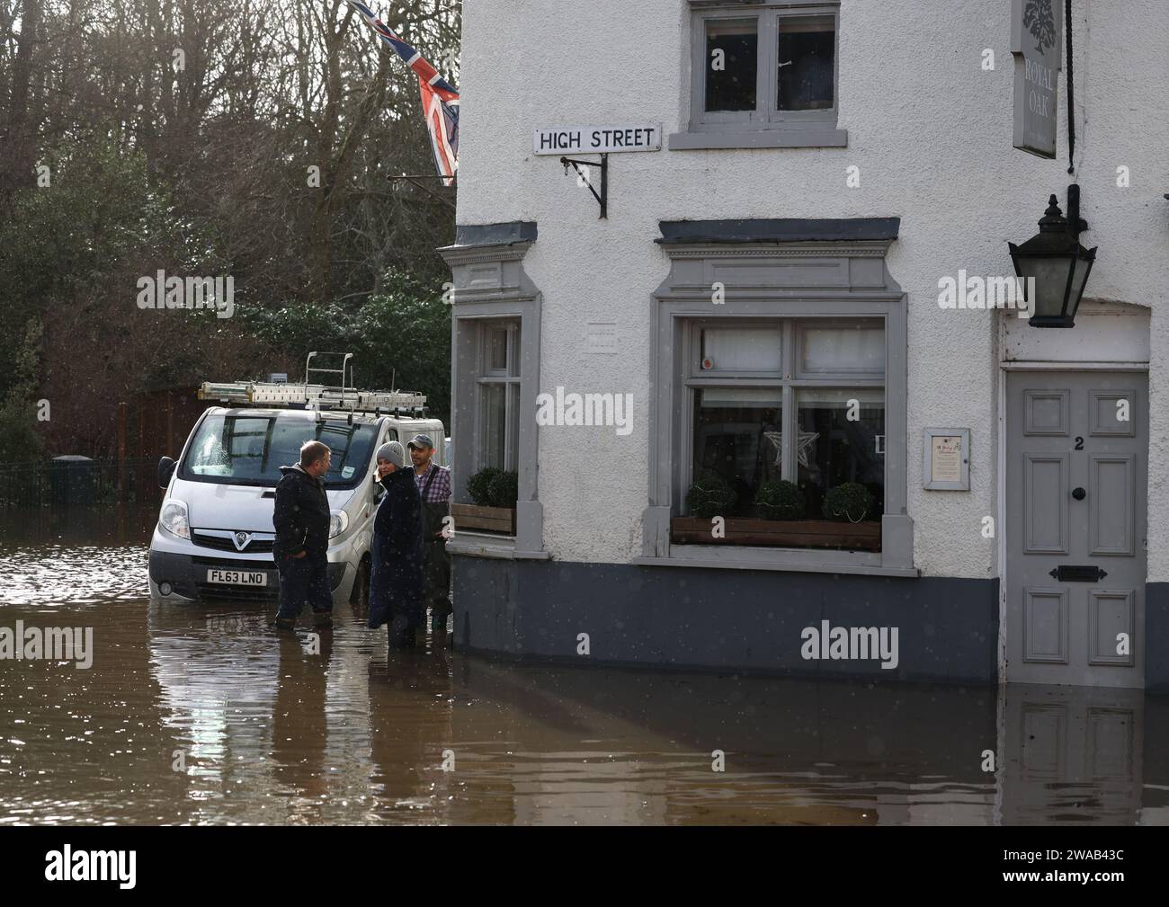 Quorn, Leicestershire, UK. 3rd January 2024. UK weather. Residents talk outside a pub sitting in flood water. Heavy rain and wind has battered large swathes of the UK after the small but potent Storm Henk hit.  Credit Darren Staples/Alamy Live News. Stock Photo