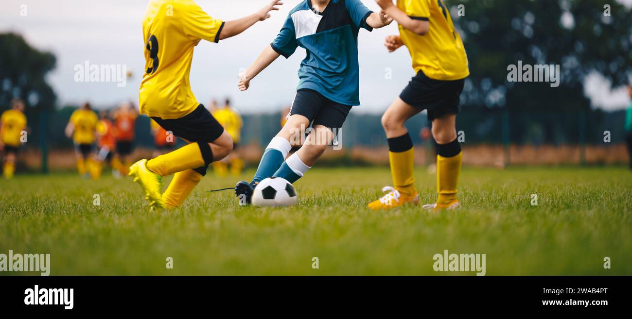 Football school. Happy kids compete in football game. Young boys playing soccer game. Kids having fun in sport. Running soccer players. Competition be Stock Photo