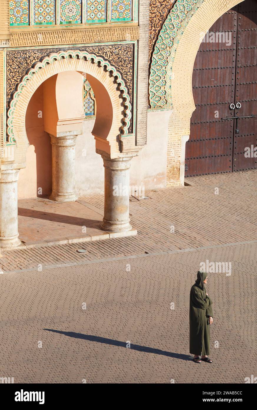 An elder man with a traditional djellaba in front of the Bab Mansour Gate, Meknes, Morocco. Stock Photo