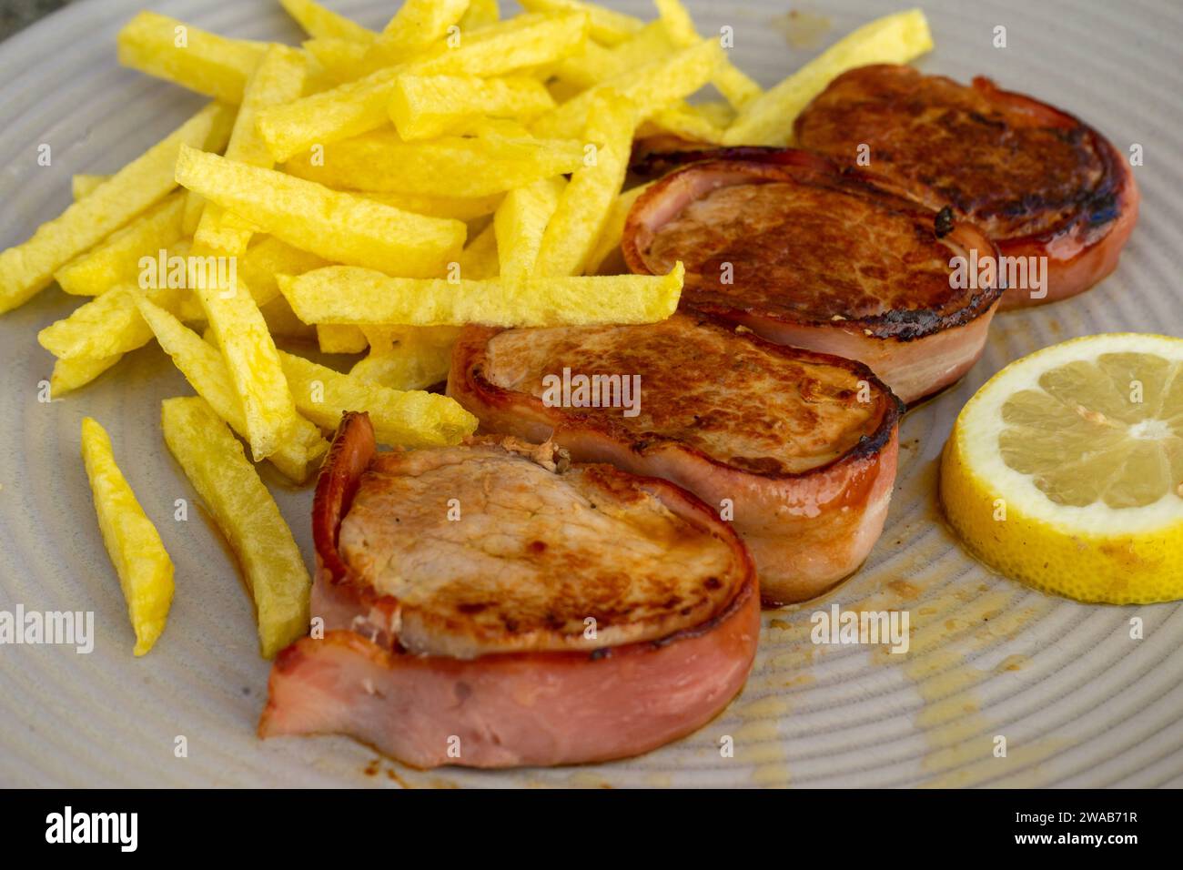 Delicious Portuguese pork tenderloin wrapped in bacon, served with