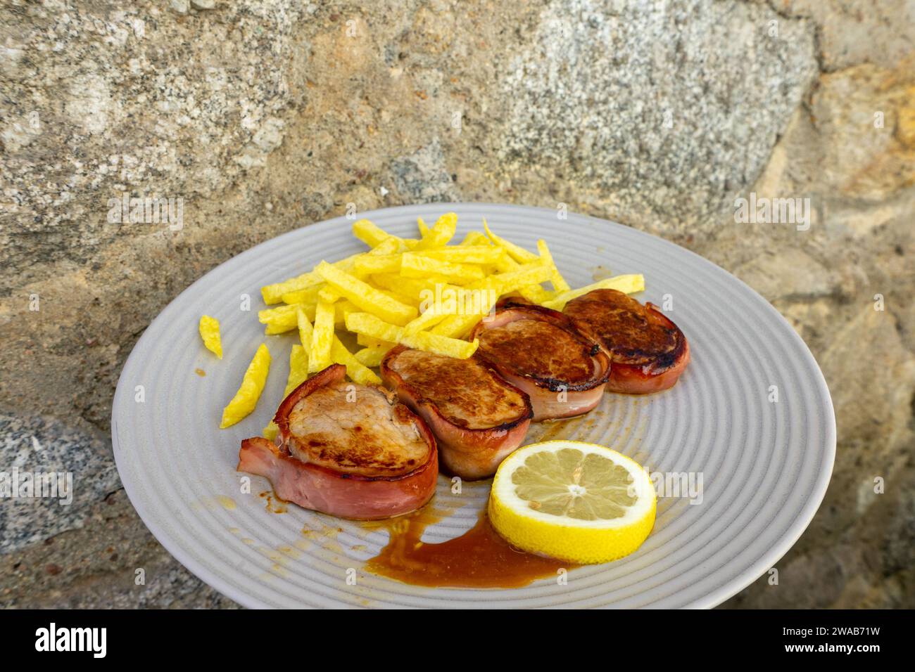 Delicious Portuguese pork tenderloin wrapped in bacon, served with