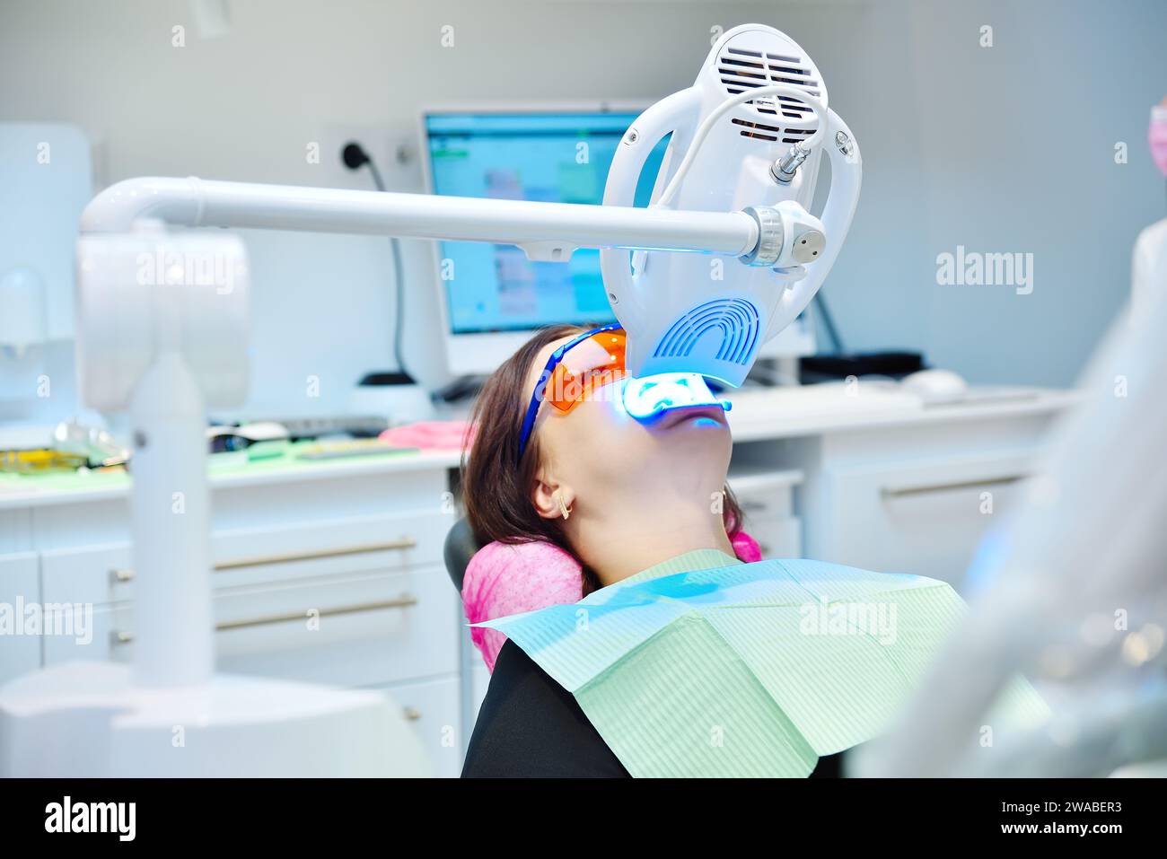 Female patient in clinic. Teeth whitening procedure with ultraviolet