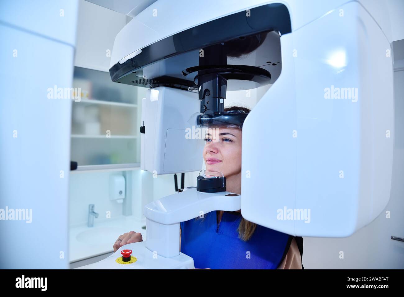 Happy woman patient make a panoramic computer tomograph in clinic. Dentistry and health care concept. Stock Photo