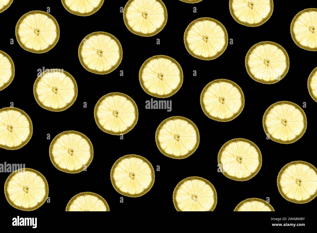 Pattern made of backlit lemon slices on black background Stock Photo