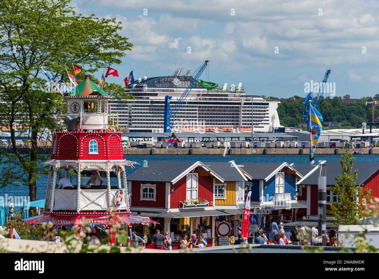 Kieler Woche auf der Reventlow Wiese, im Hintergrund der Osthafen mit einem Kreuzfahrtschiff der MSC Line Stock Photo