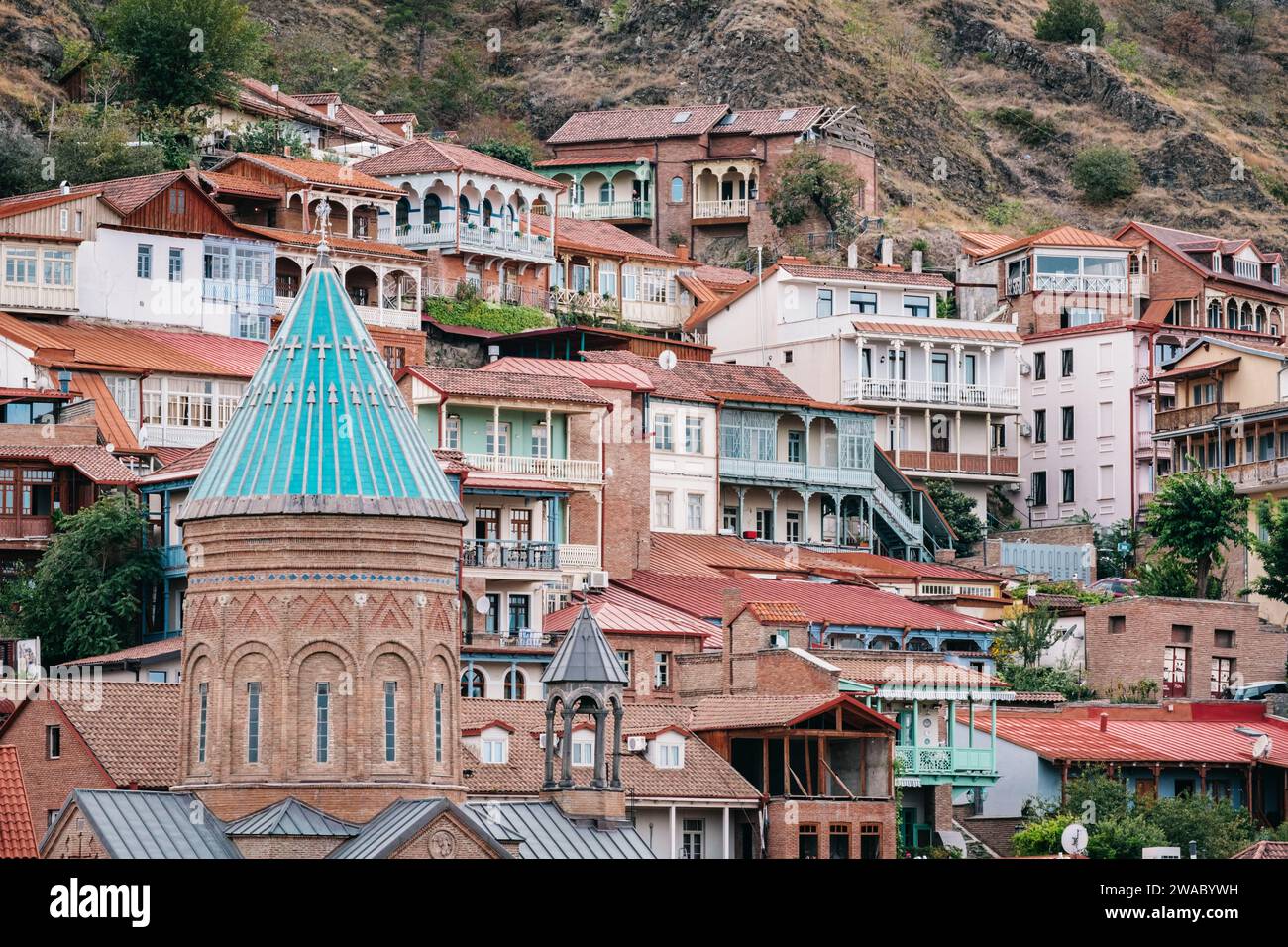 The blue roof of the bell tower of Saint George's church and the quaint facades with carved wooden balconies of Old Tbilisi Stock Photo