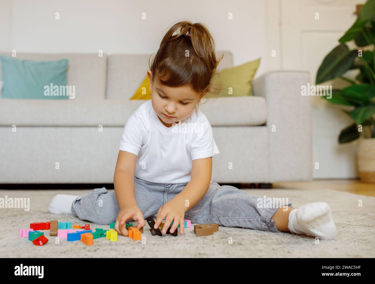 Cute Little Girl Playing With Colorful Wooden Blocks At Home Stock ...