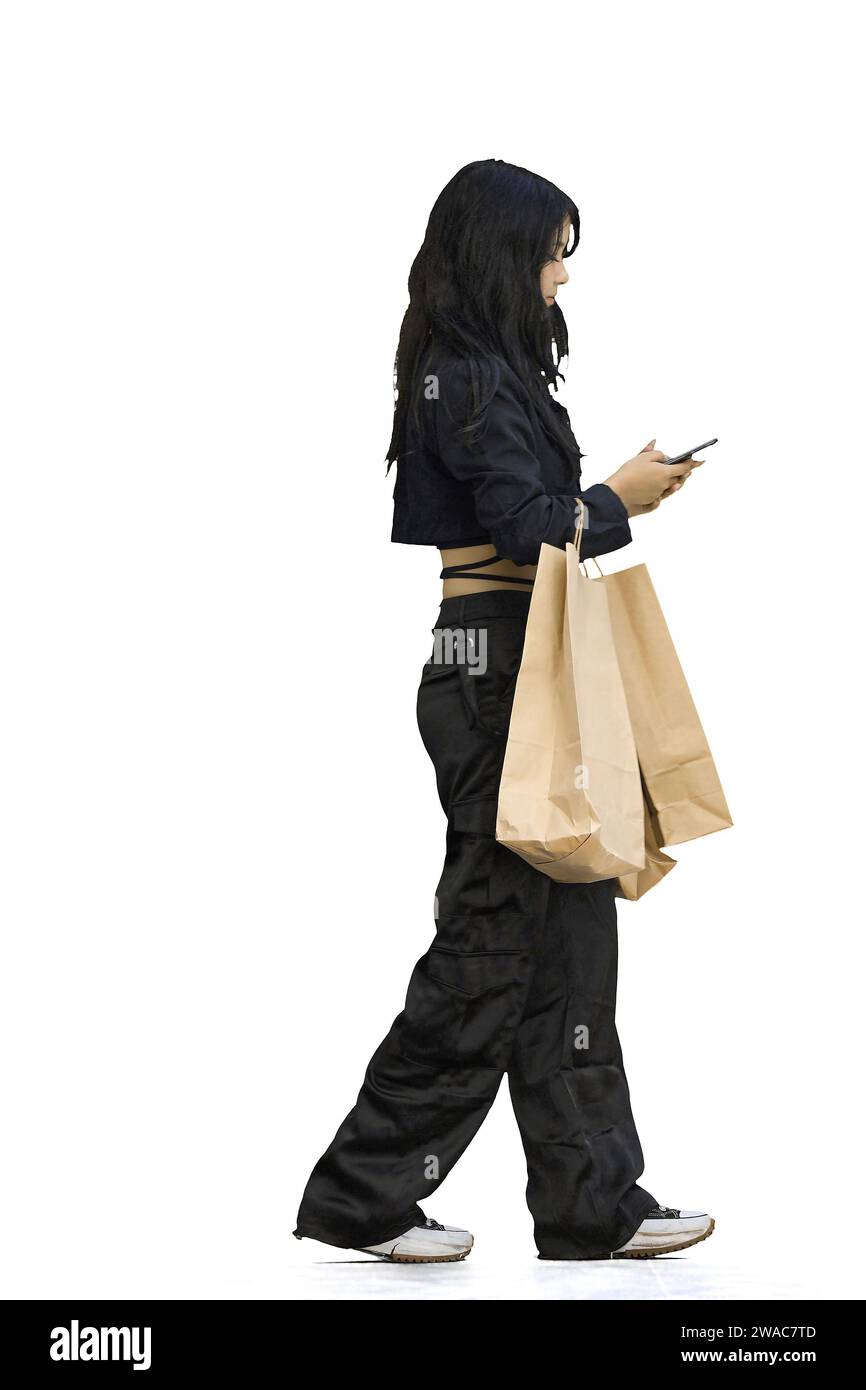 A woman in black clothes, on a white background, full-length, with bags and a phone Stock Photo