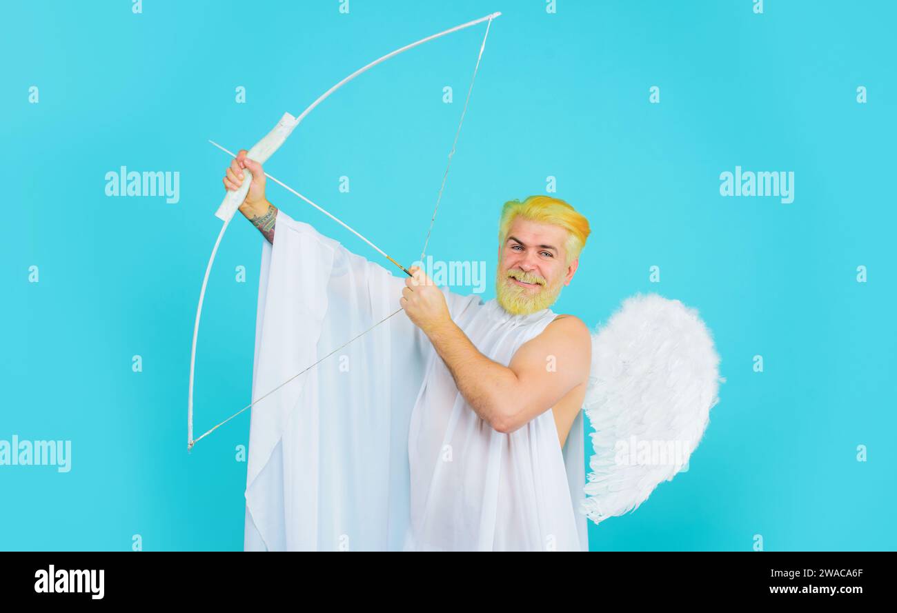 Saint Valentines Day celebration. Smiling bearded man in angel wings with bow and arrow. God of love. Valentines day Cupid shooting arrows of love Stock Photo
