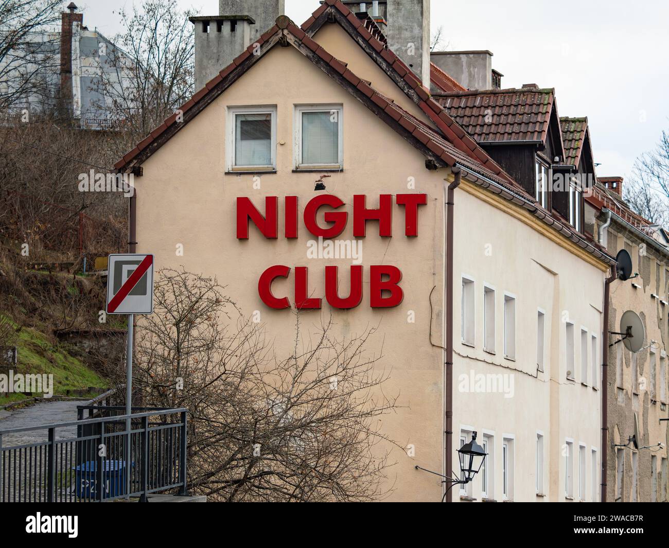 Night Club sign on a building facade in Zgorzelec. Entertainment for adult people in a small town in the border region. Nightlife party location. Stock Photo