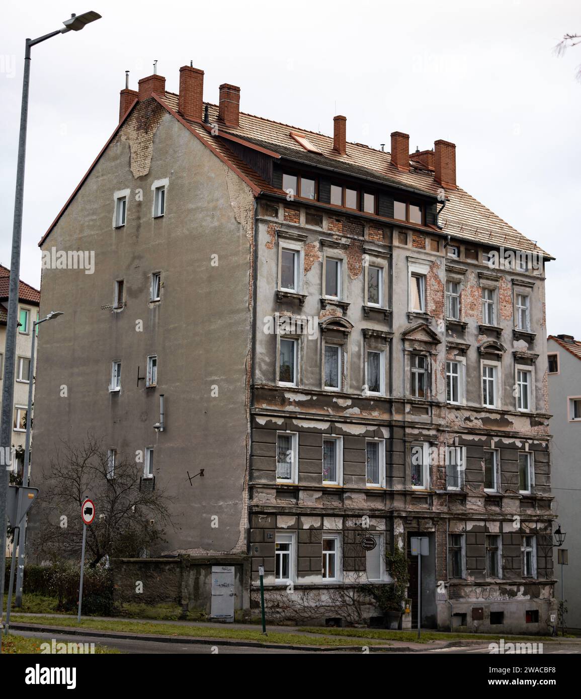 Unrenovated old building in Zgorzelec, Poland. The facade is weathered and the plaster parts are broken out. The exterior is in a bad condition. Stock Photo