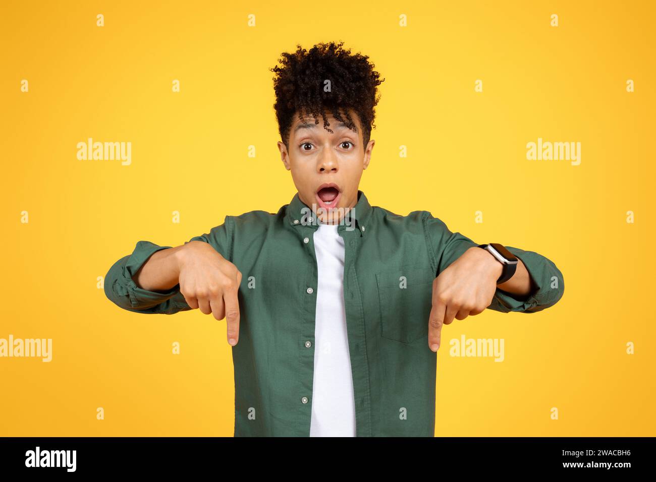 Shocked young african american man pointing down Stock Photo