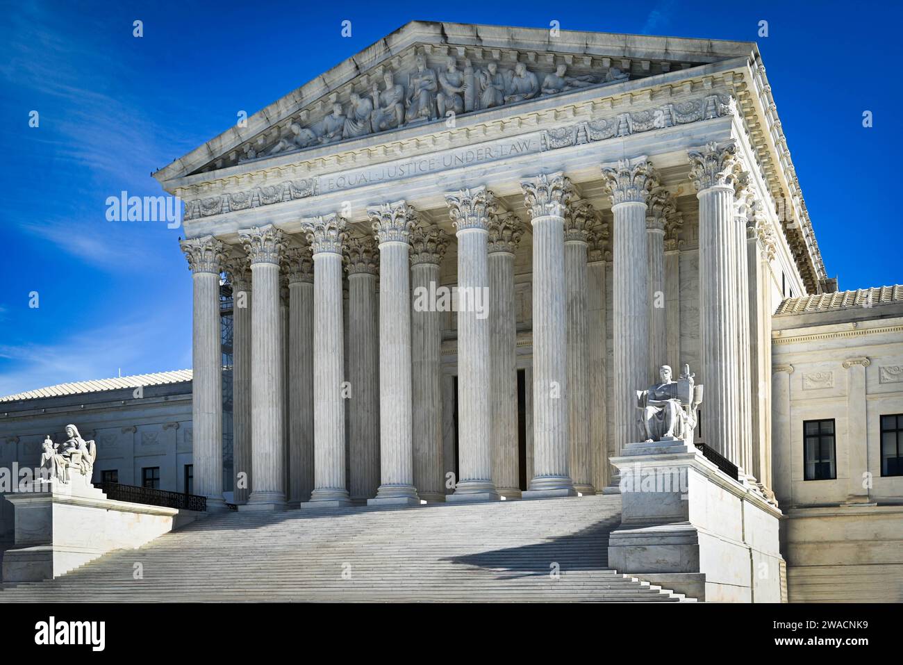US Supreme Court Building's neoclassical architecture highlights the seated white marble statues, the 'Guardian' and 'Contemplation. of Justice', DC Stock Photo