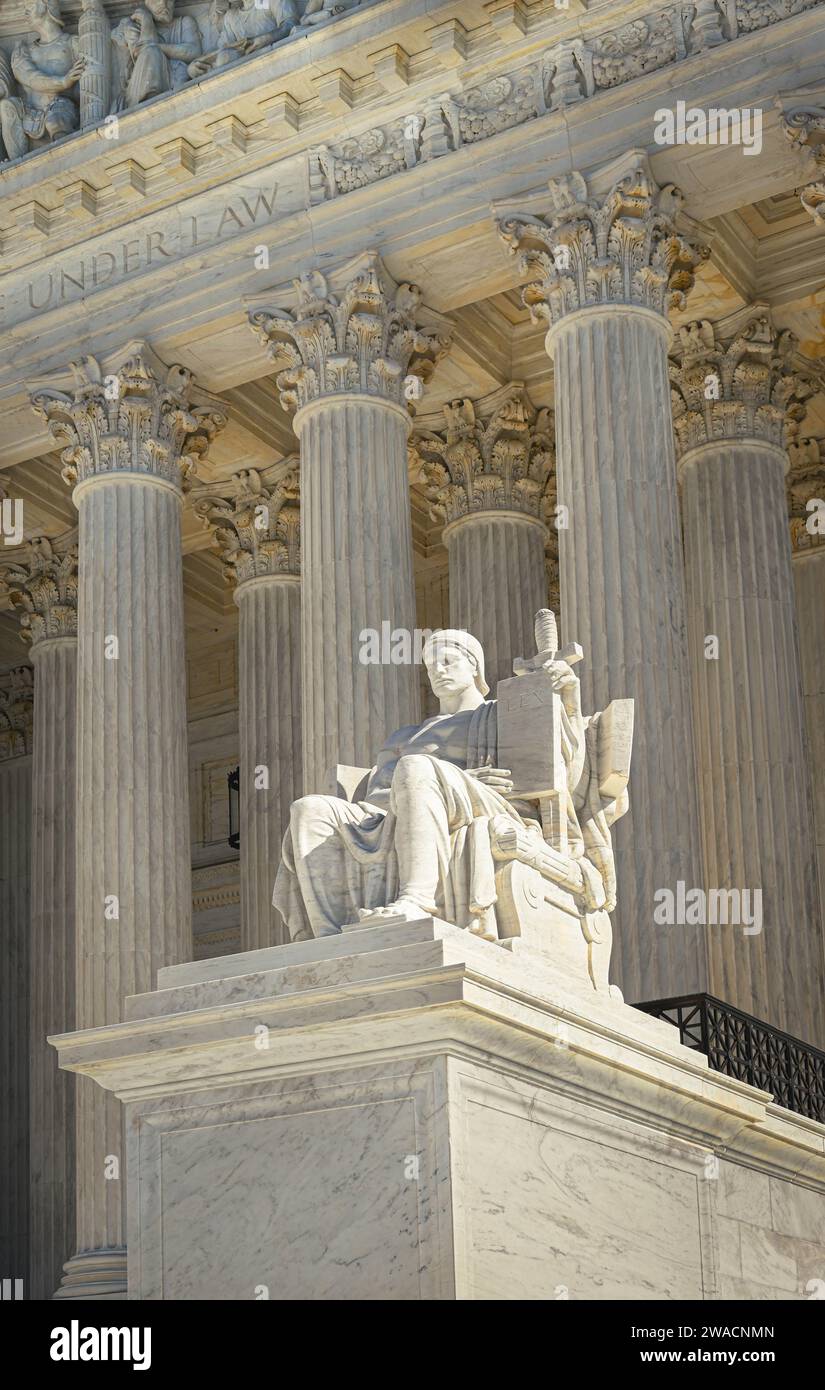 A dramatic close up of the seated marble statue 'Guardian' in foreground of neoclassical architecture of the US Supreme Court, Washington DC Stock Photo
