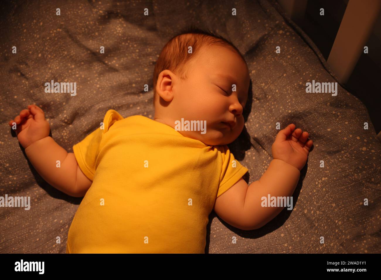 Cute newborn baby sleeping in crib at night, top view Stock Photo