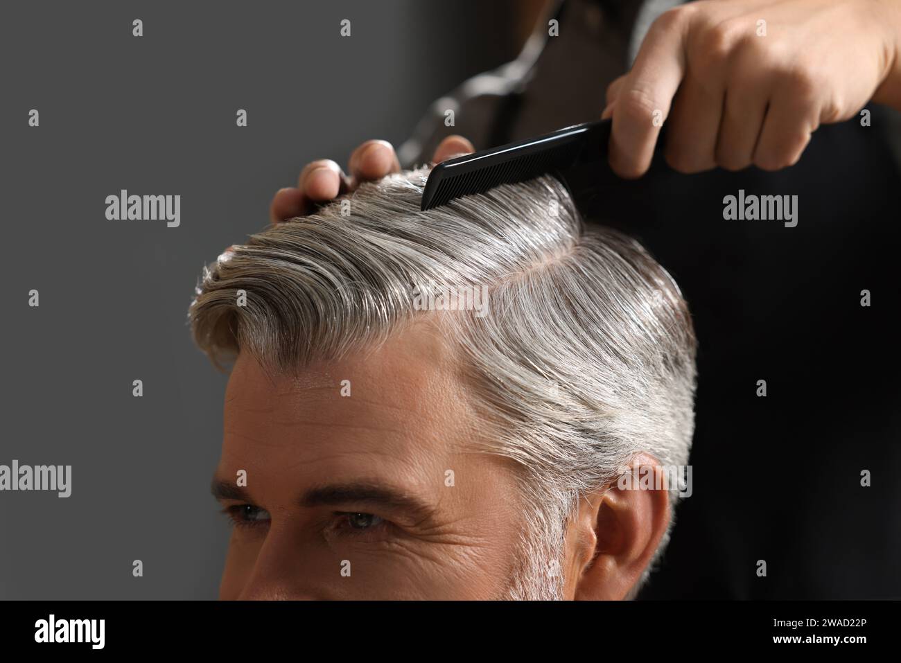 Hair styling. Professional hairdresser working with client in barbershop, closeup Stock Photo