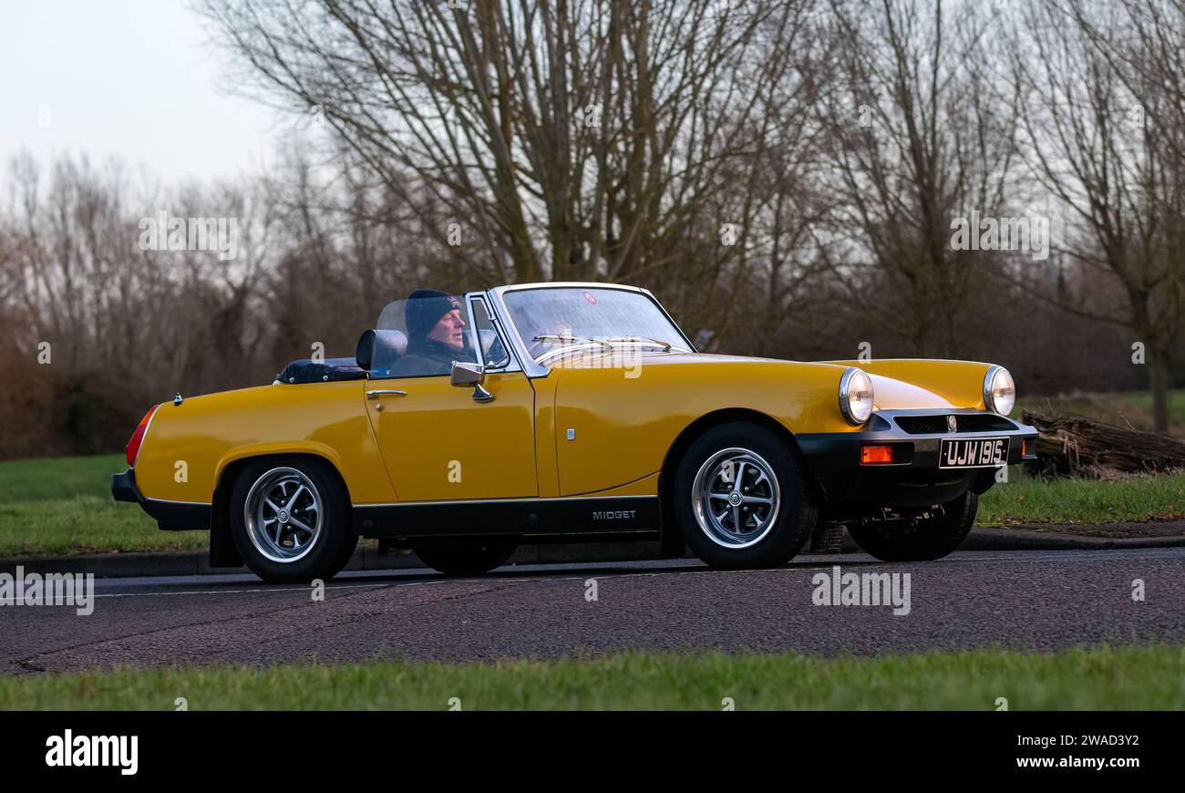 Stony Stratford,UK Jan 1st 2024.  1978 yellow MG Midget sports car arriving at Stony Stratford for the annual New Years Day vintage and classic vehicl Stock Photo