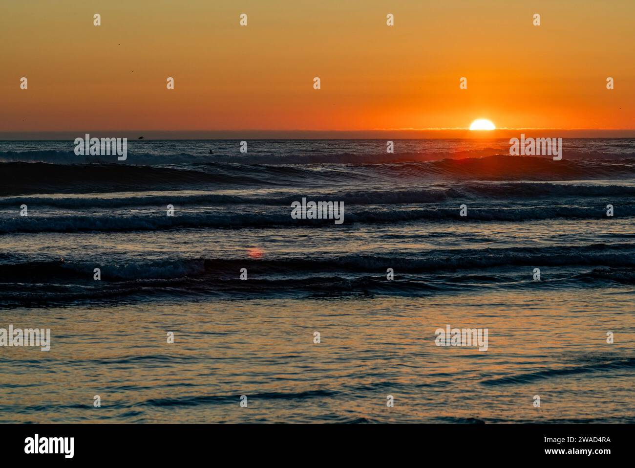 Sun setting over ocean at Cannon Beach Stock Photo