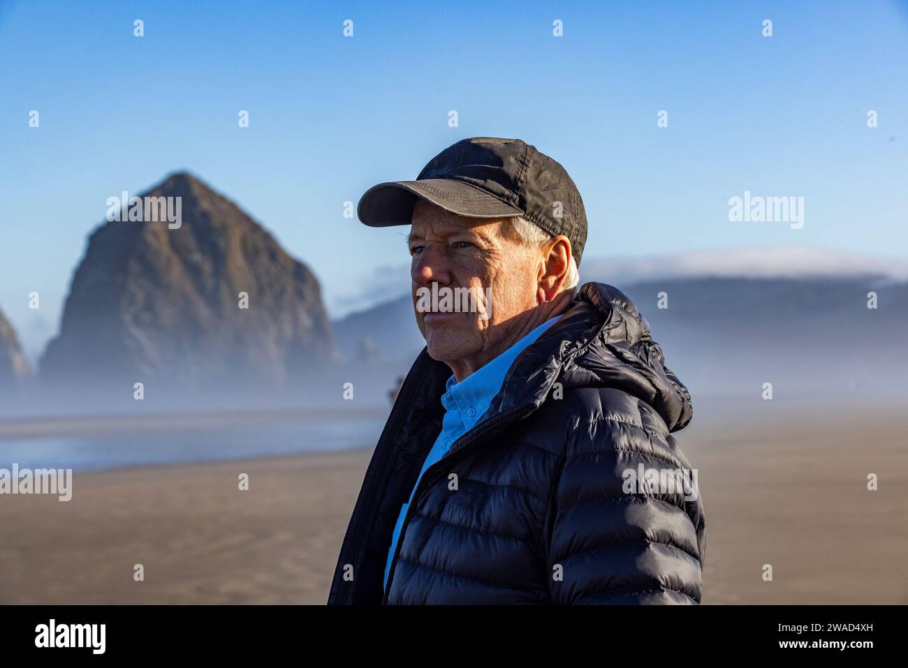 USA, Oregon, Man standing near Haystack Rock at Cannon Beach in morning mist Stock Photo