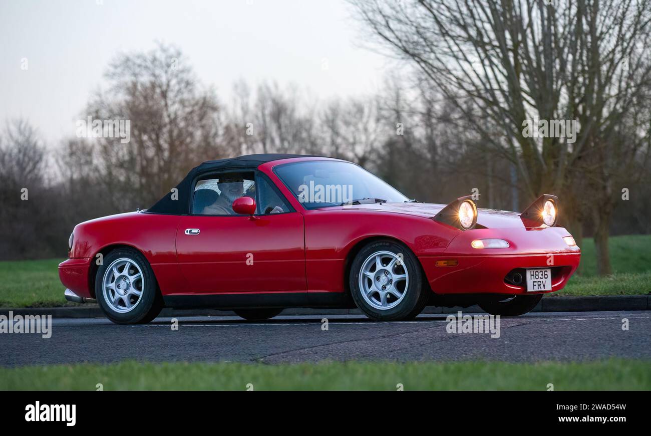 Stony Stratford,UK Jan 1st 2024. 1990 red Mazda MX-5 car with pop up headlights arriving at Stony Stratford for the annual New Years Day vintage and c Stock Photo