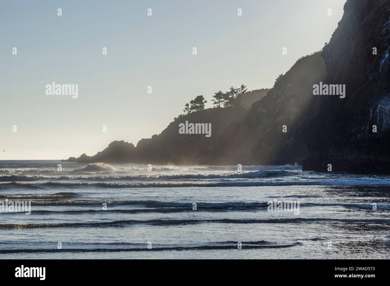 USA, Oregon, Newport, Sun shining over rocky coastline Stock Photo
