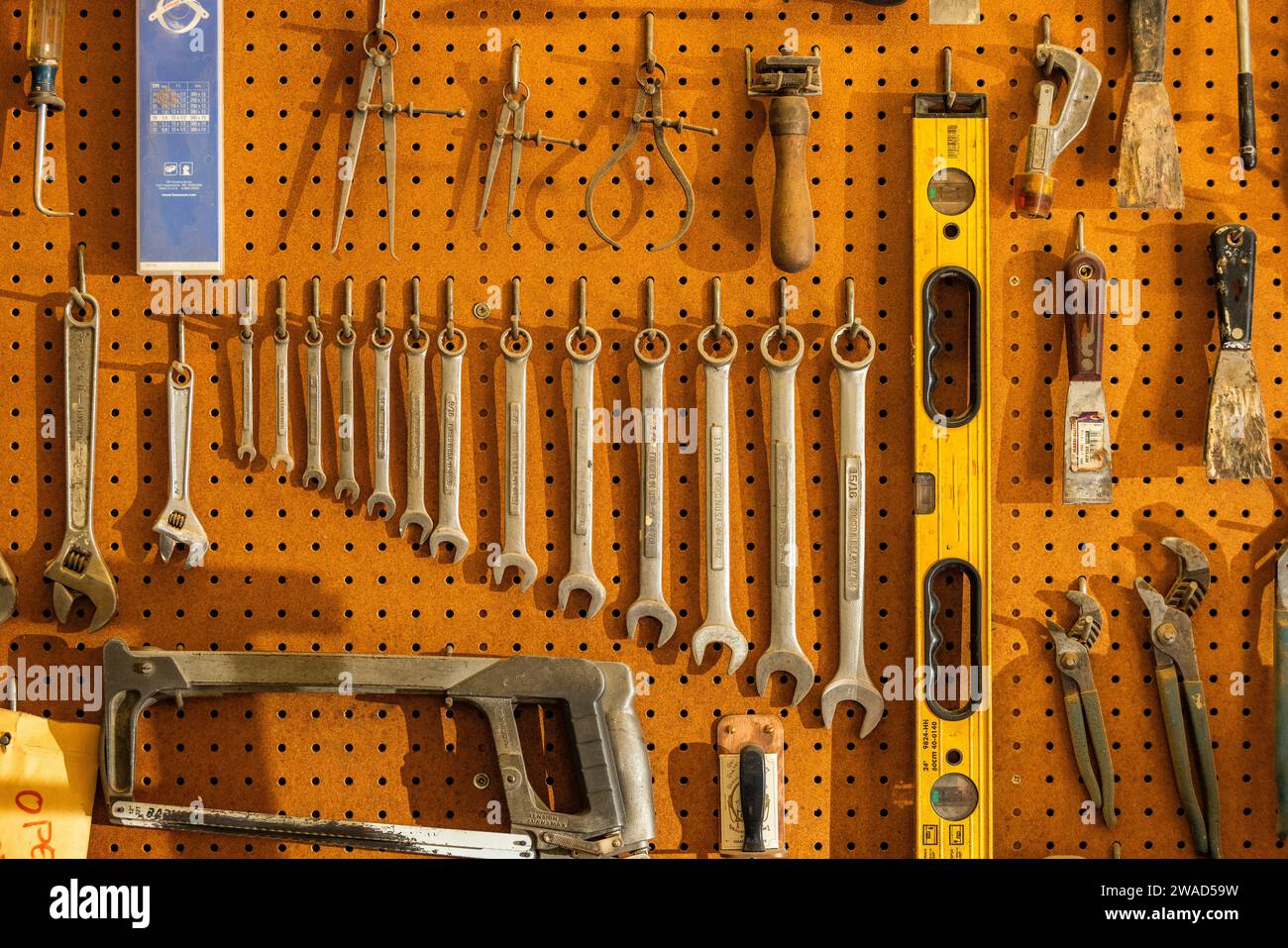 Tools on pegboard hooks on wall of wood and metal shop Stock Photo