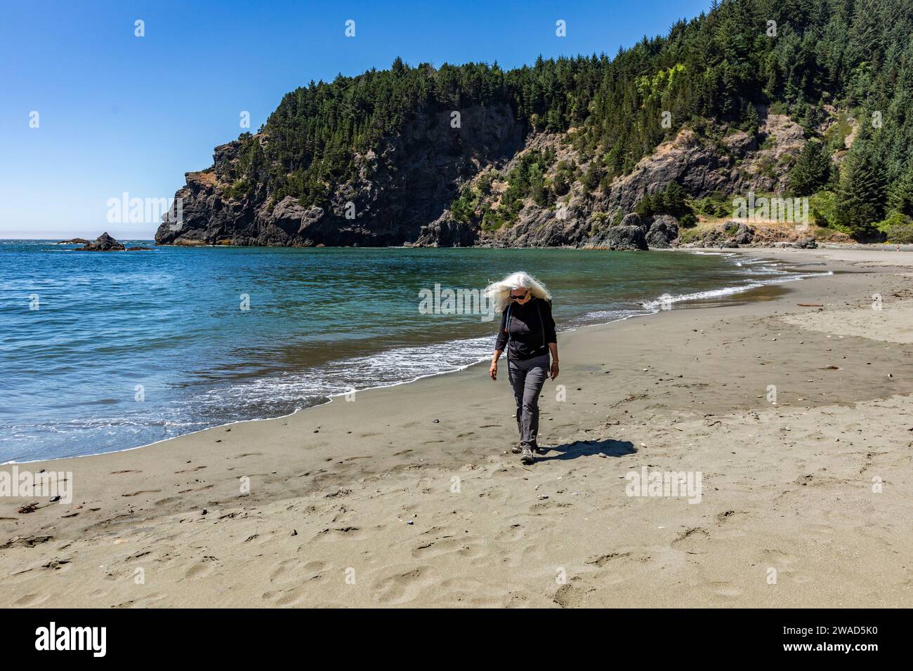 Senior woman walking on beach hi-res stock photography and images - Alamy