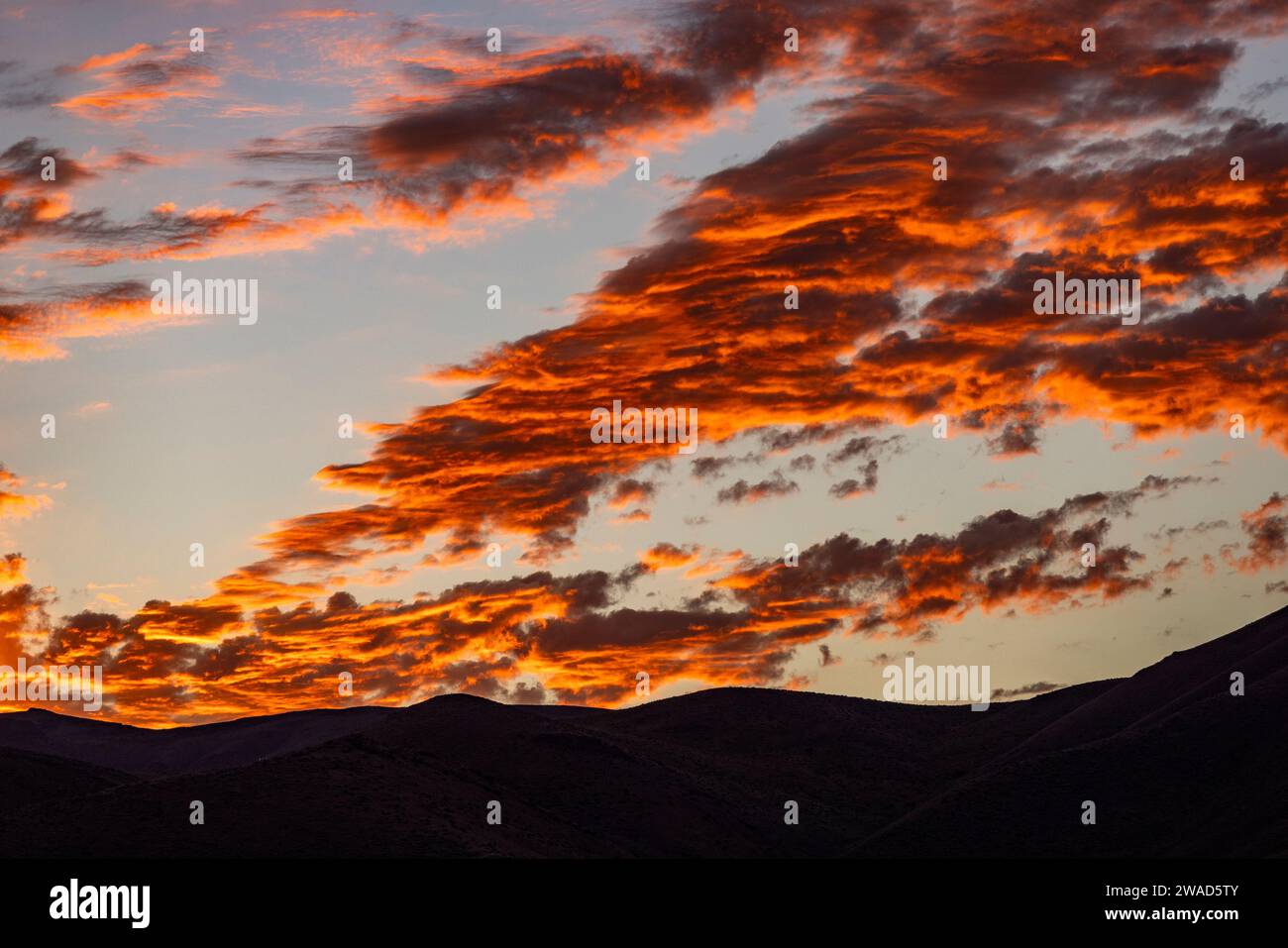 Silhouette of mountains with sunrise in background Stock Photo