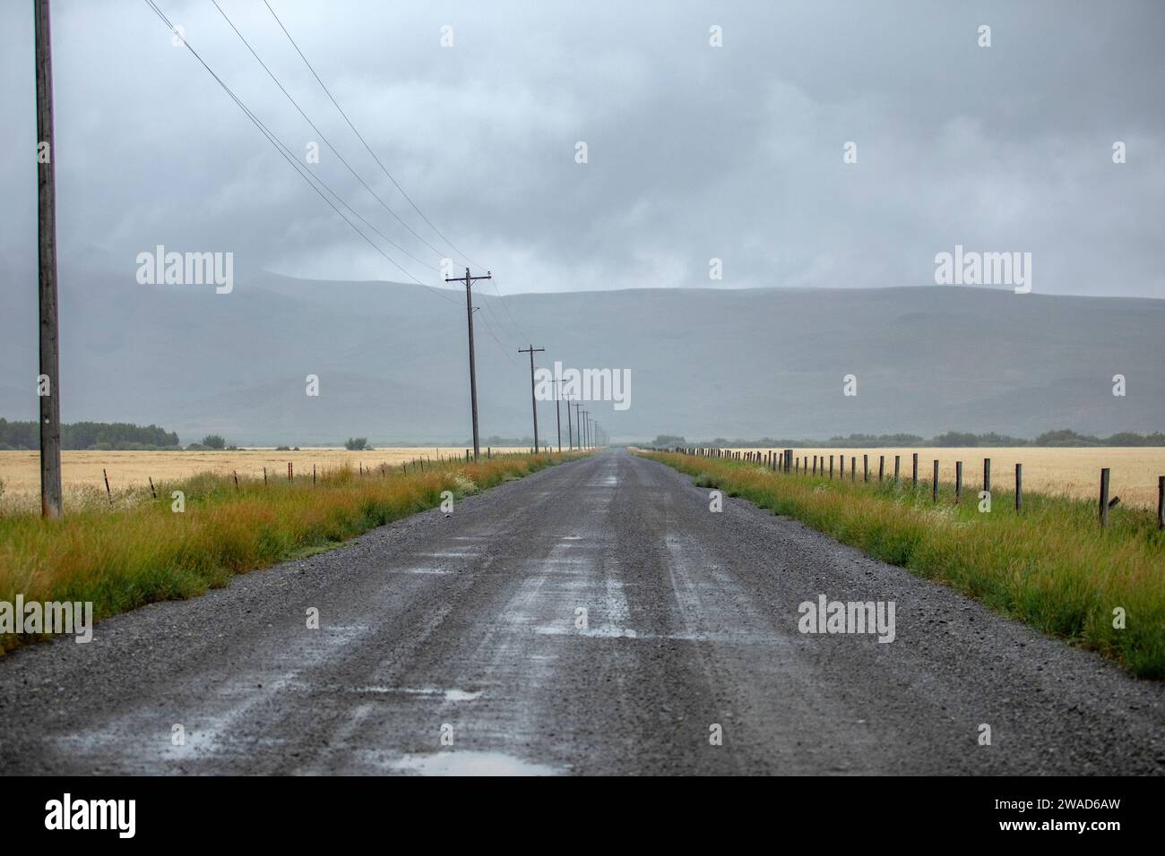 Rain clouds over dirt road in summer Stock Photo