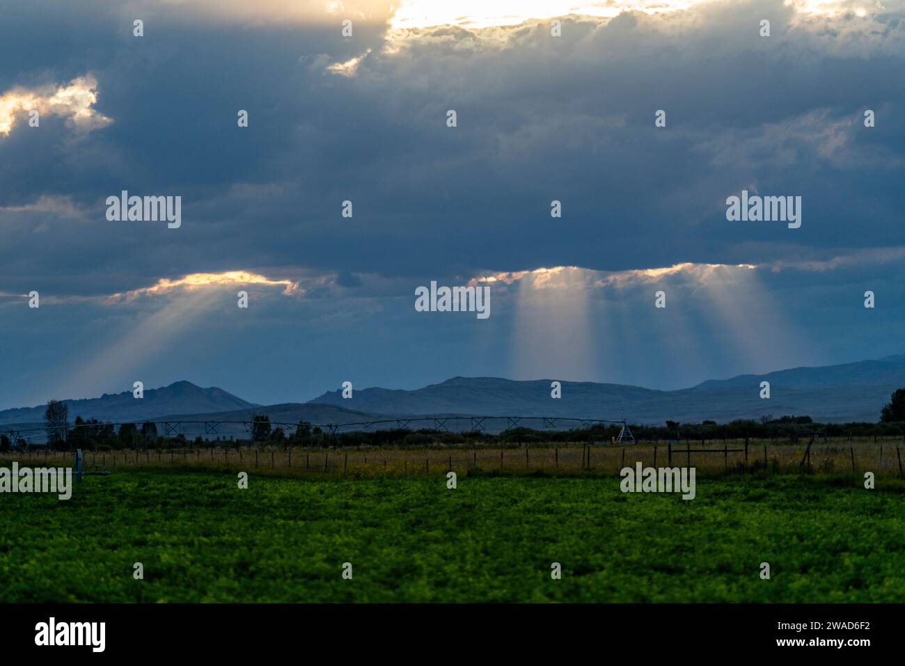 Sunlight shining through dark clouds at sunset Stock Photo