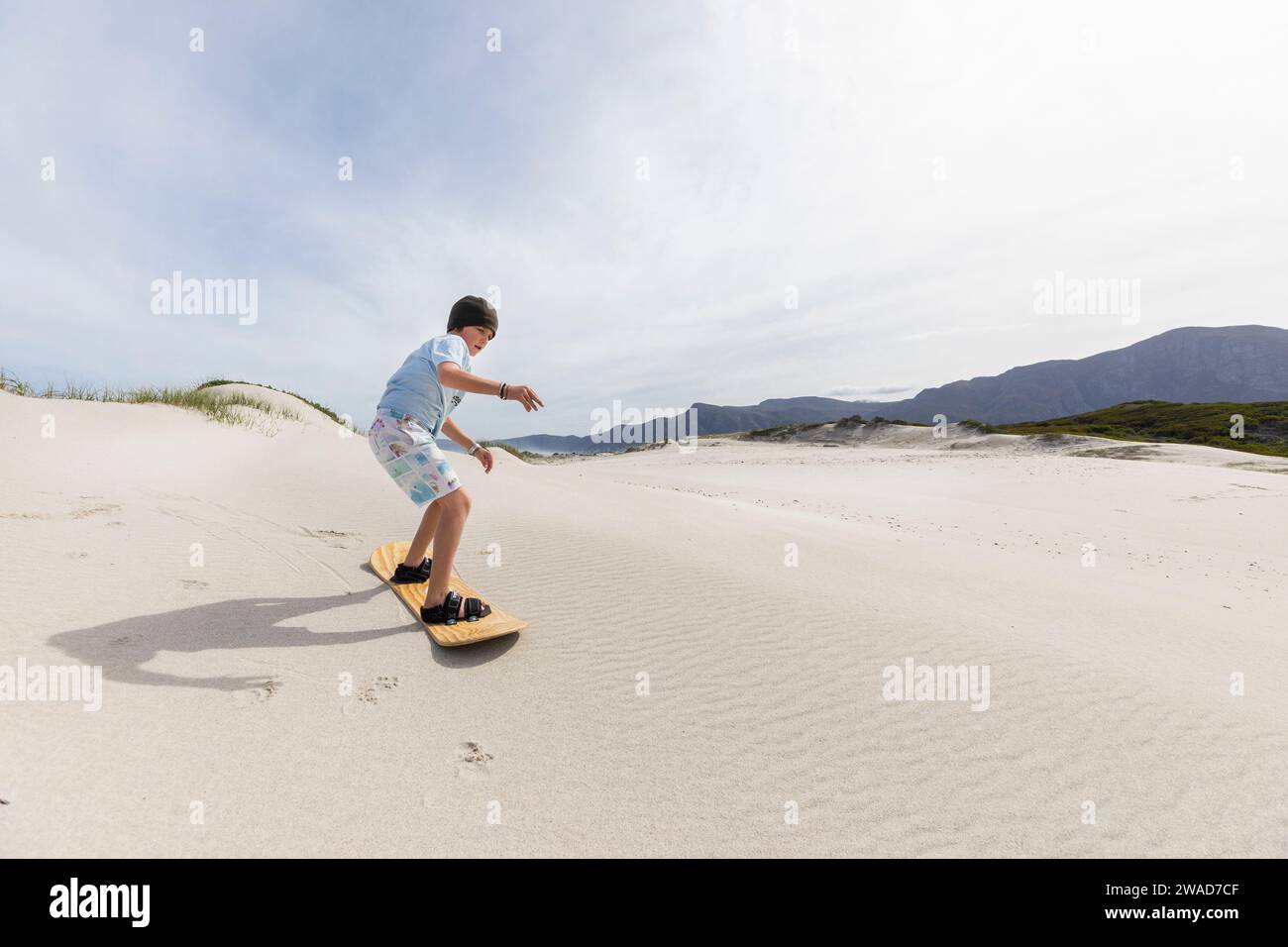 Boy (10-11) sand boarding in Walker Bay Nature Reserve Stock Photo