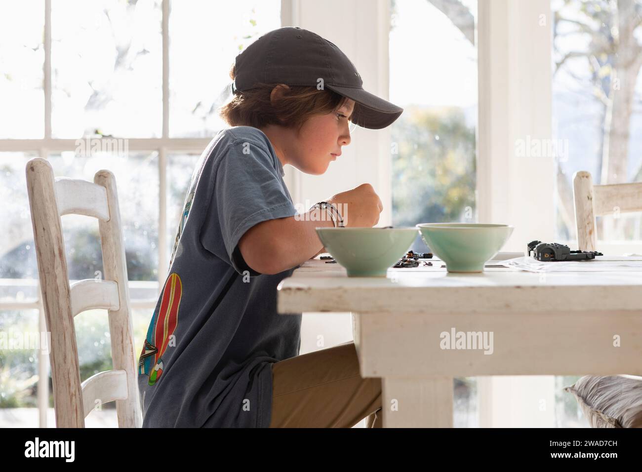 Boy (10-11) playing at dining table Stock Photo