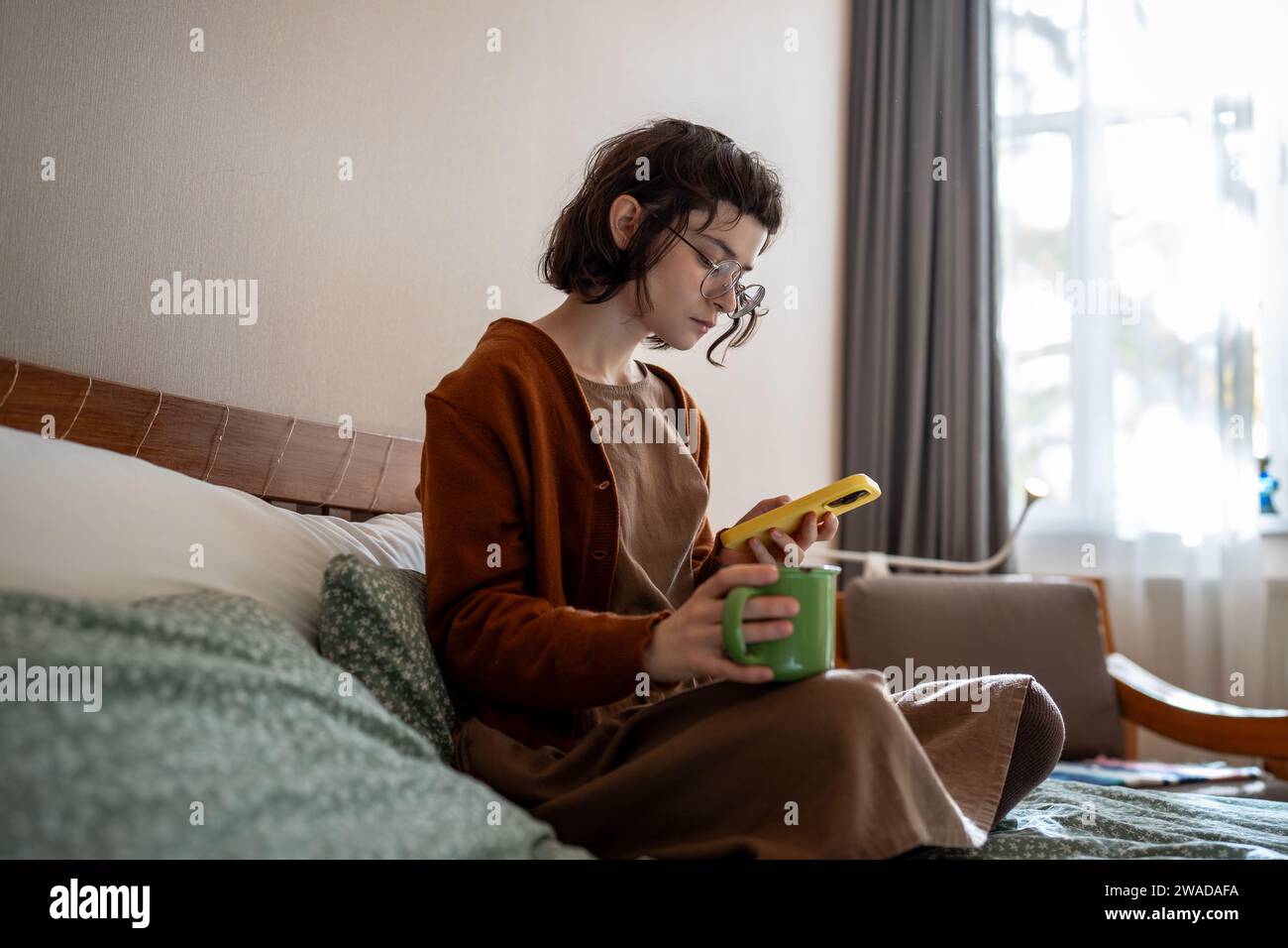 Introverted teenage girl spending sunny weekend at home, scrolling social networks, news in internet Stock Photo