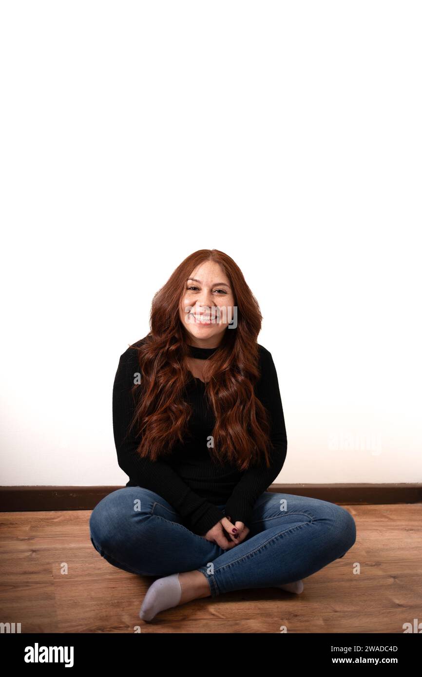 redhead woman sitting on the floor smiling Stock Photo - Alamy