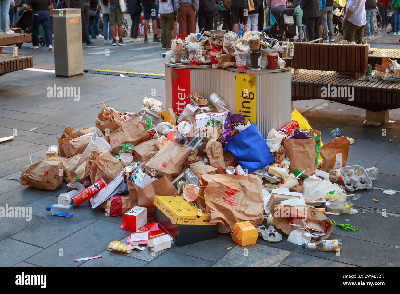 Overflowing rubbish and recycling bins surrounded with fast food and drink containers. Auckland, New Zealand Stock Photo