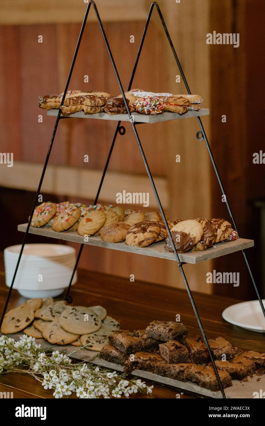 A wooden layered tray with an assortment of freshly-baked cookies and other bakery items Stock Photo